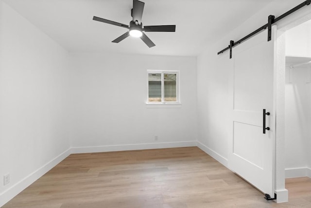 813 Cardiff Dr, Austin, TX 78745 - unfurnished bedroom featuring a barn door, light wood-style floors, and ceiling fan