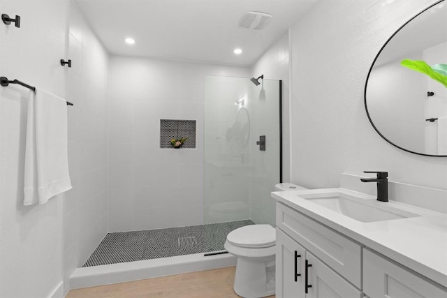 813 Cardiff Dr, Austin, TX 78745 - bathroom featuring vanity, a tile shower, toilet, recessed lighting, and wood finished floors
