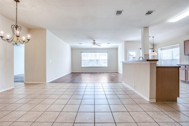 612 Arrowood Pl, Round Rock, TX 78665 - unfurnished living room with light tile patterned flooring, a ceiling fan, a chandelier, and baseboards