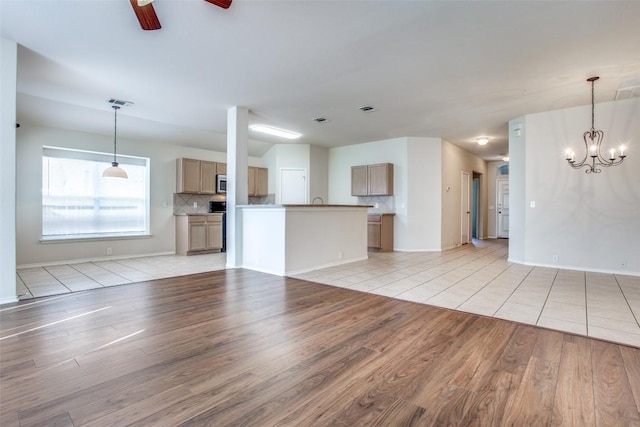 612 Arrowood Pl, Round Rock, TX 78665 - unfurnished living room with light wood finished floors, a chandelier, a ceiling fan, and baseboards