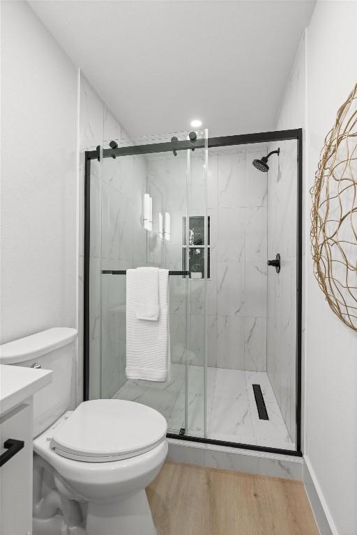 903 Cardiff Dr, Austin, TX 78745 - full bath with toilet, a marble finish shower, vanity, and wood finished floors