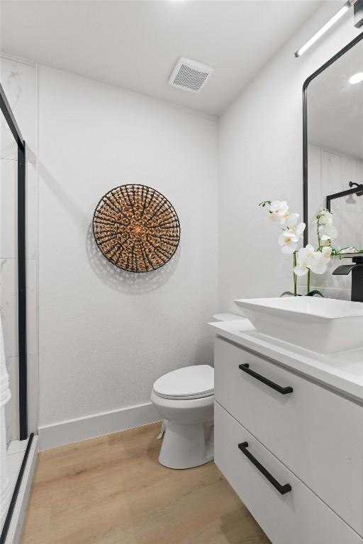903 Cardiff Dr, Austin, TX 78745 - bathroom featuring wood finished floors, vanity, and a stall shower