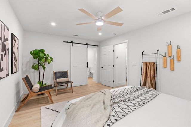 903 Cardiff Dr, Austin, TX 78745 - bedroom featuring a barn door, light wood-type flooring, baseboards, and recessed lighting