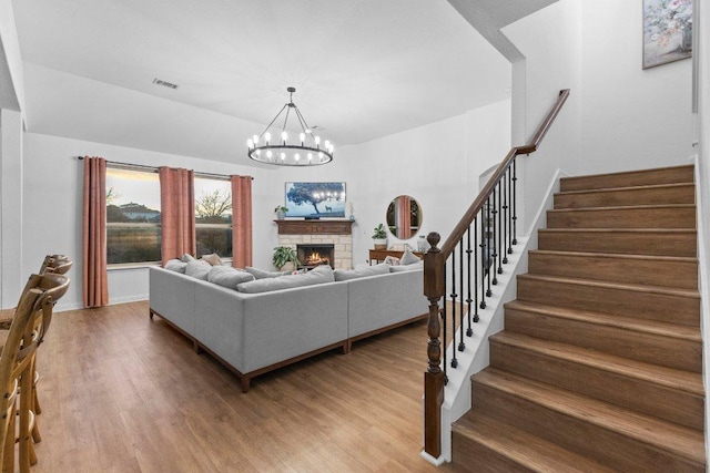 103 Bellagio Dr, Lakeway, TX 78734 - living area with stairs, wood finished floors, a chandelier, and a fireplace
