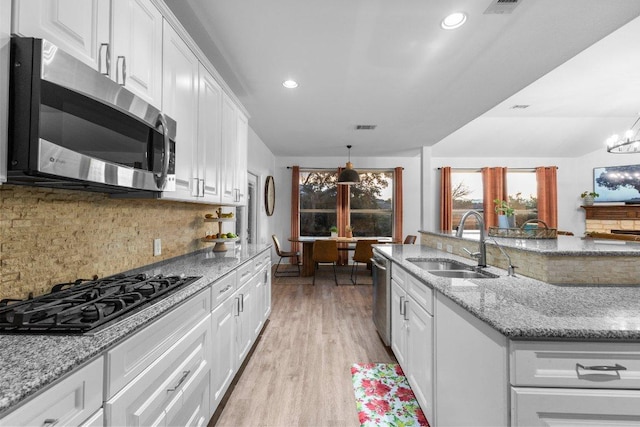 103 Bellagio Dr, Lakeway, TX 78734 - kitchen with stainless steel appliances, a sink, white cabinetry, decorative backsplash, and light wood-style floors