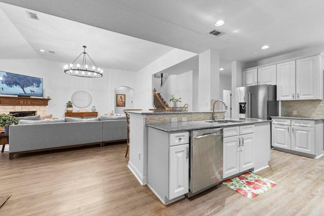 103 Bellagio Dr, Lakeway, TX 78734 - kitchen with appliances with stainless steel finishes, a sink, light wood finished floors, open floor plan, and recessed lighting