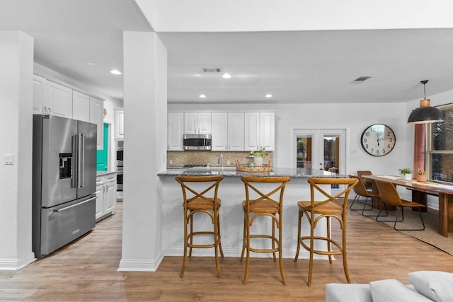 103 Bellagio Dr, Lakeway, TX 78734 - kitchen with appliances with stainless steel finishes, white cabinetry, a kitchen breakfast bar, recessed lighting, and a sink