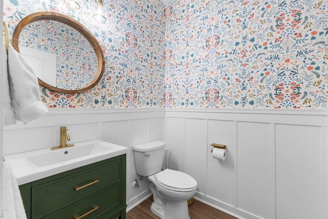 103 Bellagio Dr, Lakeway, TX 78734 - bathroom with wallpapered walls, vanity, a wainscoted wall, toilet, and wood finished floors