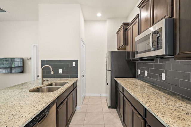 5012 Yucca Bloom Dr, Georgetown, TX 78626 - kitchen with stainless steel appliances, a sink, light stone countertops, tasteful backsplash, and dark brown cabinetry