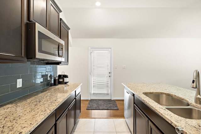 5012 Yucca Bloom Dr, Georgetown, TX 78626 - kitchen featuring stainless steel appliances, dark brown cabinetry, backsplash, light tile patterned floors, and light stone counters