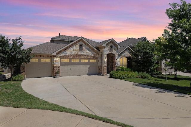 5012 Yucca Bloom Dr, Georgetown, TX 78626 - french country style house featuring a garage, driveway, stone siding, a lawn, and a shingled roof