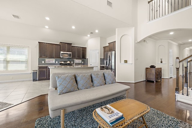 5012 Yucca Bloom Dr, Georgetown, TX 78626 - living area with arched walkways, dark wood-style flooring, baseboards, stairs, and a high ceiling