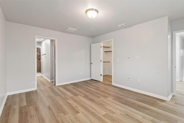 424 Wapiti Rd, Buda, TX 78610 - unfurnished bedroom with a spacious closet, light wood-type flooring, and baseboards
