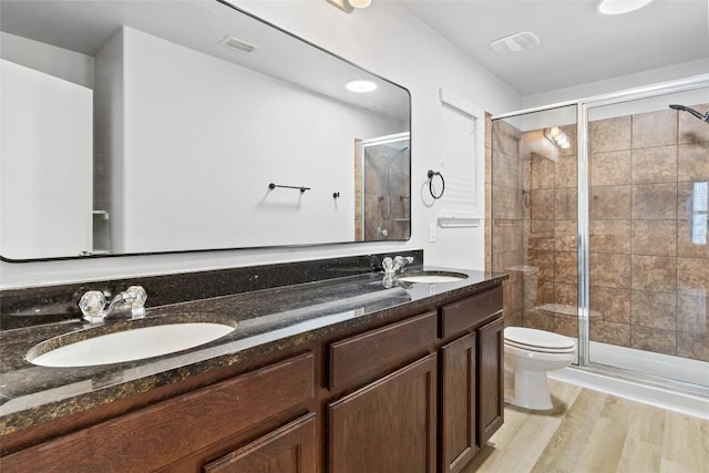 424 Wapiti Rd, Buda, TX 78610 - full bathroom featuring double vanity, toilet, a shower stall, and wood finished floors