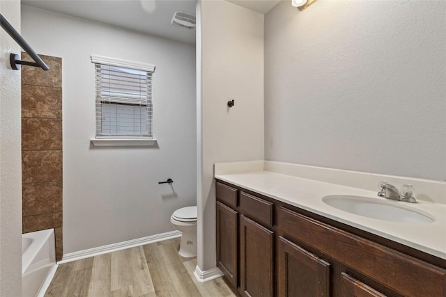 424 Wapiti Rd, Buda, TX 78610 - bathroom featuring toilet, vanity, wood finished floors, baseboards, and washtub / shower combination