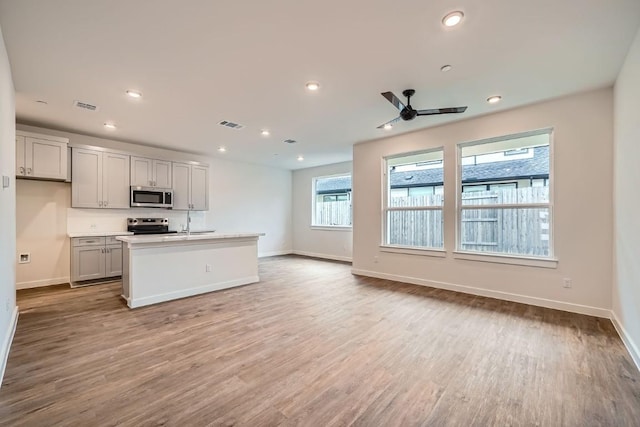 2600 Gattis School Rd Unit 1102, Round Rock, TX 78664 - kitchen featuring appliances with stainless steel finishes, baseboards, a ceiling fan, wood finished floors, and recessed lighting