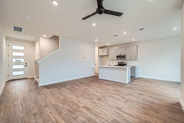 2600 Gattis School Rd Unit 1102, Round Rock, TX 78664 - unfurnished living room featuring a ceiling fan, baseboards, light wood-style floors, recessed lighting, and stairway