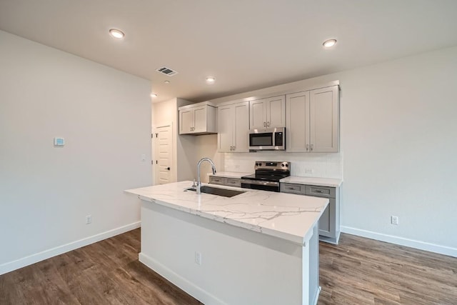 2600 Gattis School Rd Unit 1102, Round Rock, TX 78664 - kitchen featuring appliances with stainless steel finishes, a sink, baseboards, wood finished floors, and gray cabinets