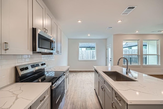 2600 Gattis School Rd Unit 1102, Round Rock, TX 78664 - kitchen with appliances with stainless steel finishes, a sink, light wood-style floors, baseboards, and recessed lighting
