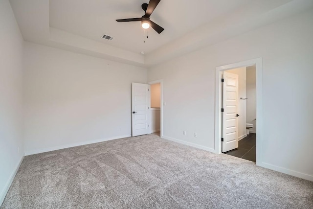 2600 Gattis School Rd Unit 1102, Round Rock, TX 78664 - unfurnished bedroom featuring dark colored carpet, a raised ceiling, baseboards, and ensuite bathroom