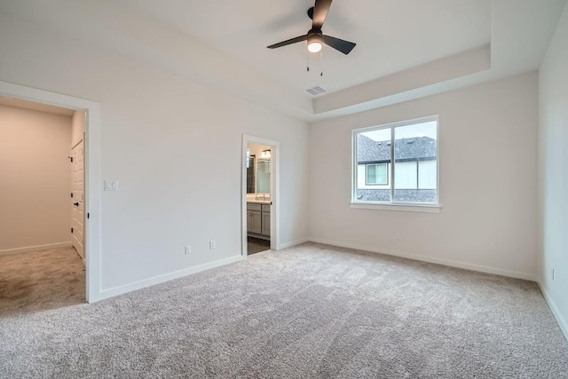 2600 Gattis School Rd Unit 1102, Round Rock, TX 78664 - unfurnished bedroom with light carpet, baseboards, a raised ceiling, and connected bathroom