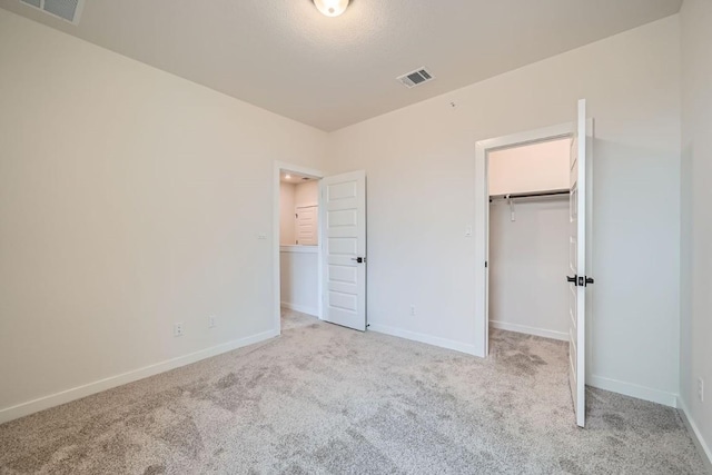 2600 Gattis School Rd Unit 1102, Round Rock, TX 78664 - unfurnished bedroom featuring light colored carpet, baseboards, and a walk in closet