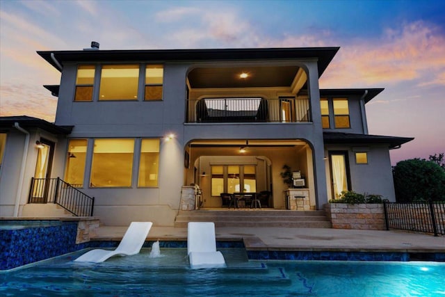 2037 Portobello Rd, Leander, TX 78641 - back of house featuring a balcony, a patio, an outdoor pool, and stucco siding