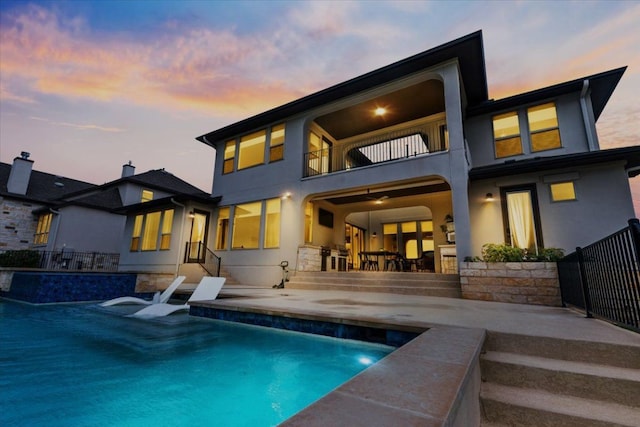 2037 Portobello Rd, Leander, TX 78641 - rear view of house with a balcony, a patio area, an outdoor pool, and stucco siding