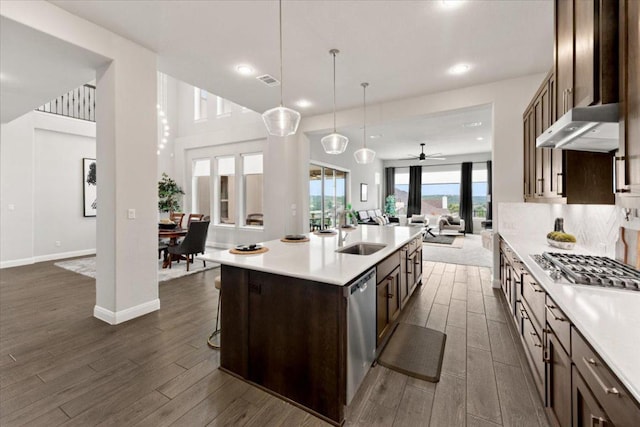 2037 Portobello Rd, Leander, TX 78641 - kitchen with open floor plan, a sink, appliances with stainless steel finishes, dark wood finished floors, and light countertops