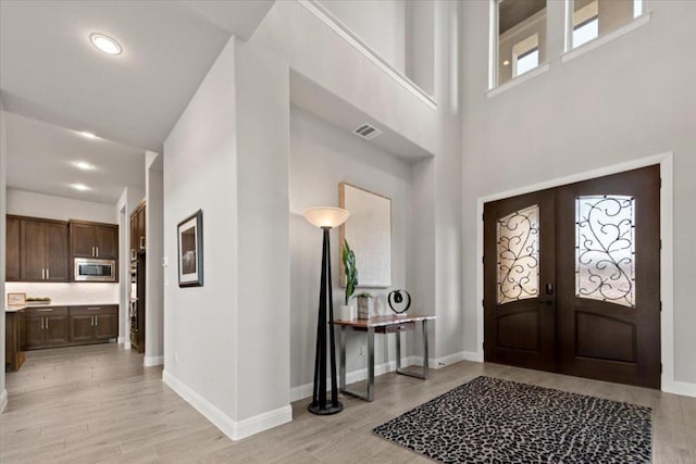 2037 Portobello Rd, Leander, TX 78641 - foyer entrance with light wood-type flooring, french doors, a towering ceiling, and recessed lighting