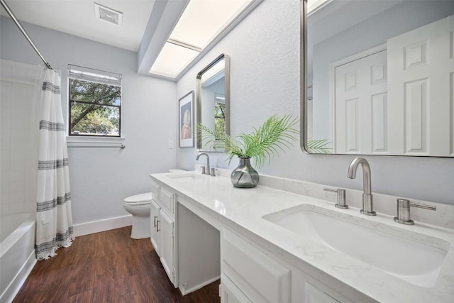 12025 Cherie Dr, Austin, TX 78758 - bathroom featuring toilet, double vanity, shower / tub combo, wood finished floors, and baseboards