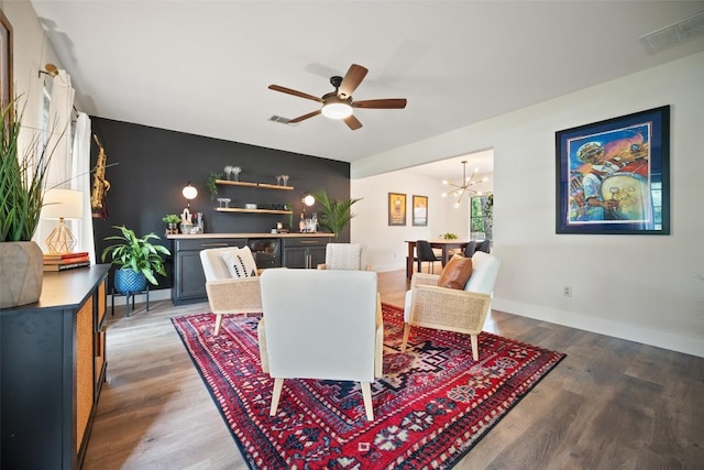 12025 Cherie Dr, Austin, TX 78758 - dining space featuring wood finished floors, an accent wall, ceiling fan, a chandelier, and baseboards