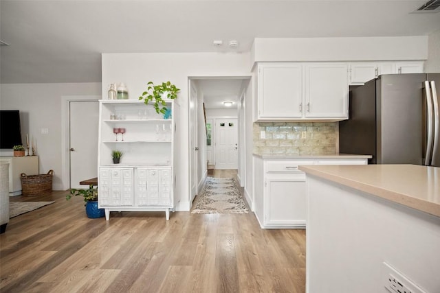 12025 Cherie Dr, Austin, TX 78758 - kitchen with freestanding refrigerator, light countertops, white cabinetry, and light wood-style flooring