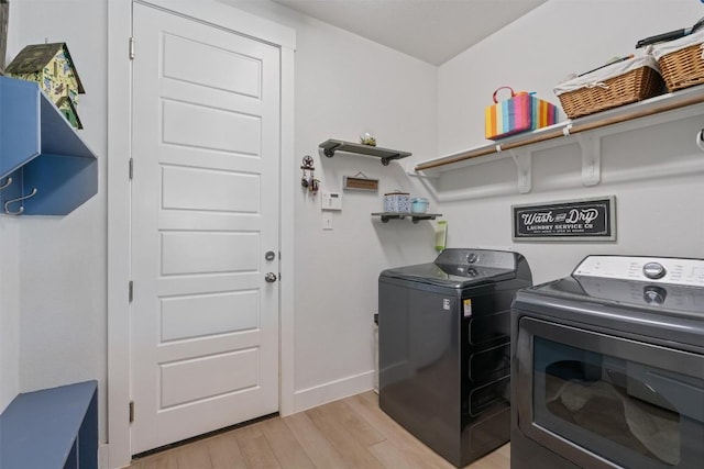 653 Coyote Creek Way, Kyle, TX 78640 - laundry room with separate washer and dryer, light wood finished floors, and baseboards