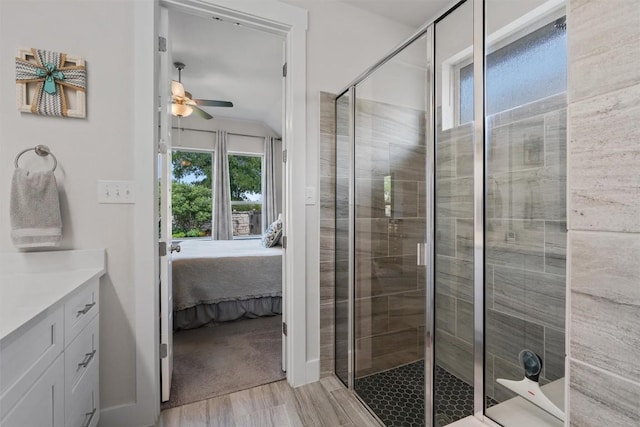 653 Coyote Creek Way, Kyle, TX 78640 - bathroom featuring ensuite bath, a ceiling fan, a stall shower, vanity, and wood finished floors