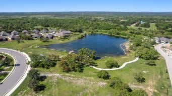 653 Coyote Creek Way, Kyle, TX 78640 - aerial overview of property's location with a large body of water and a forest