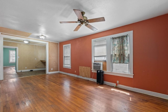 604 Harris Ave, Austin, TX 78705 - unfurnished living room featuring wood-type flooring, a ceiling fan, and baseboards
