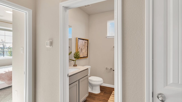 166 Caddo Bnd, Kyle, TX 78640 - half bath featuring vanity, toilet, wood finished floors, and baseboards