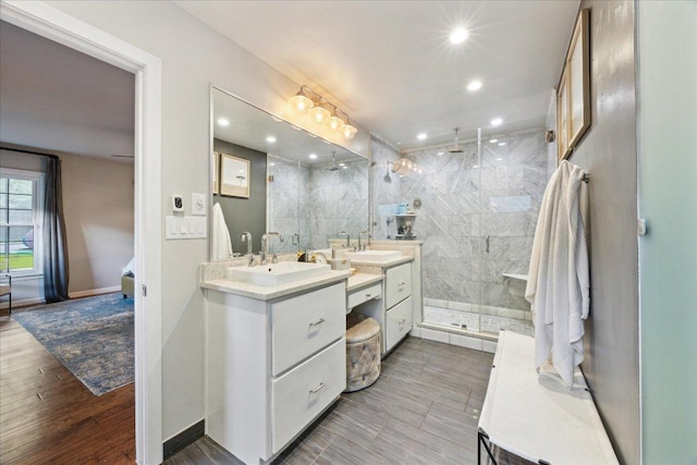 5808 Marilyn Dr, Austin, TX 78757 - bathroom featuring vanity, a marble finish shower, baseboards, recessed lighting, and wood finished floors