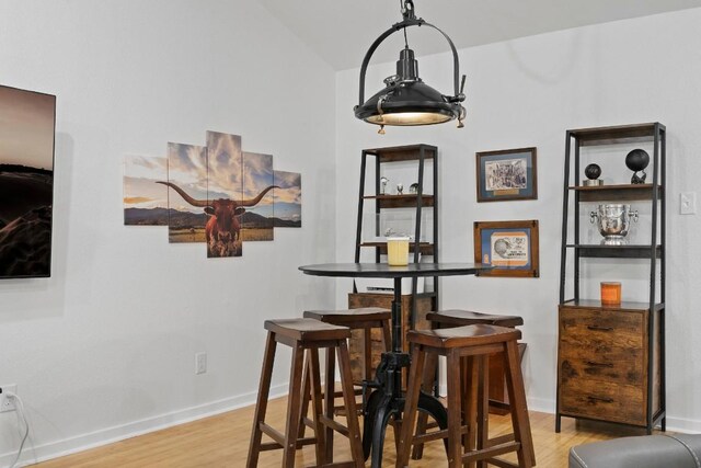 3601 Menchaca Rd Unit 215, Austin, TX 78704 - dining room featuring light wood finished floors, baseboards, and vaulted ceiling