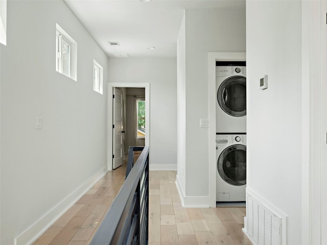 2910 Garwood St Unit A, Austin, TX 78702 - laundry area with stacked washing machine and dryer, baseboards, and light wood-type flooring