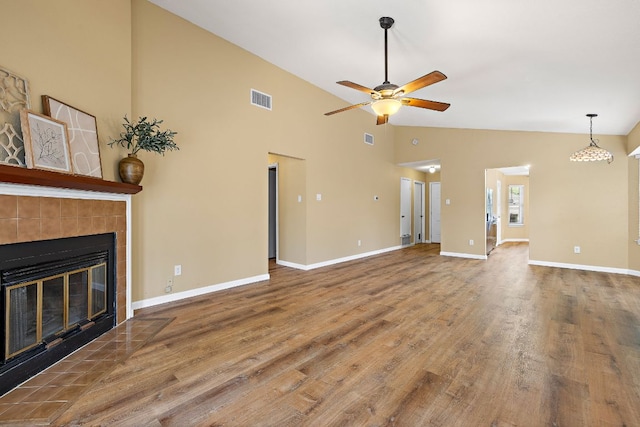 11611 Prairie Hen Ln, Austin, TX 78758 - unfurnished living room with a ceiling fan, a fireplace, wood finished floors, baseboards, and high vaulted ceiling