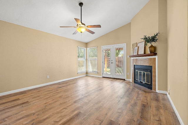 11611 Prairie Hen Ln, Austin, TX 78758 - unfurnished living room with wood finished floors, a ceiling fan, baseboards, a tile fireplace, and french doors