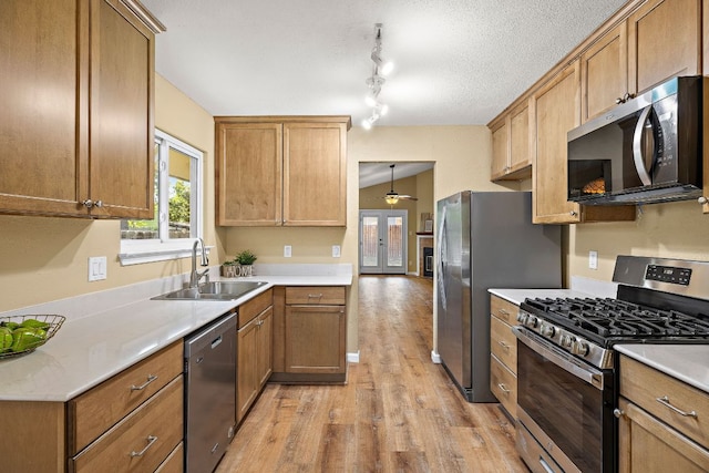 11611 Prairie Hen Ln, Austin, TX 78758 - kitchen featuring stainless steel appliances, a sink, light wood-type flooring, ceiling fan, and light countertops