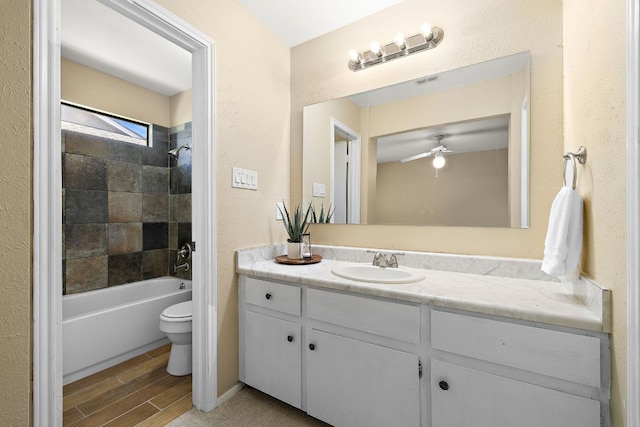 11611 Prairie Hen Ln, Austin, TX 78758 - full bathroom with toilet, vanity, shower / bath combination, wood finished floors, and a ceiling fan