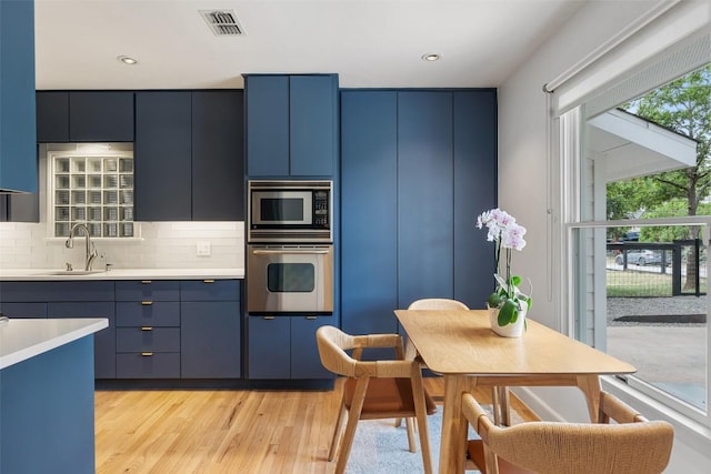 2103 W 10th St, Austin, TX 78703 - kitchen with stainless steel appliances, blue cabinets, light countertops, light wood finished floors, and recessed lighting