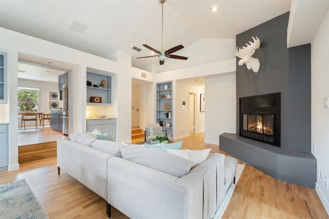 2103 W 10th St, Austin, TX 78703 - living area with light wood-style floors, built in shelves, a ceiling fan, lofted ceiling, and a fireplace