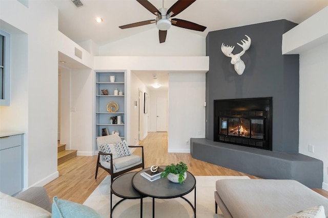 2103 W 10th St, Austin, TX 78703 - living area with light wood finished floors, a ceiling fan, stairway, built in shelves, and baseboards