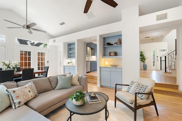 2103 W 10th St, Austin, TX 78703 - living room featuring ceiling fan, light wood-type flooring, high vaulted ceiling, stairs, and french doors