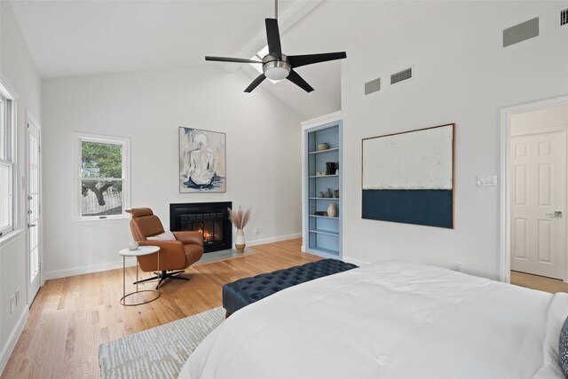 2103 W 10th St, Austin, TX 78703 - bedroom with a fireplace with flush hearth, light wood-style floors, high vaulted ceiling, baseboards, and ceiling fan